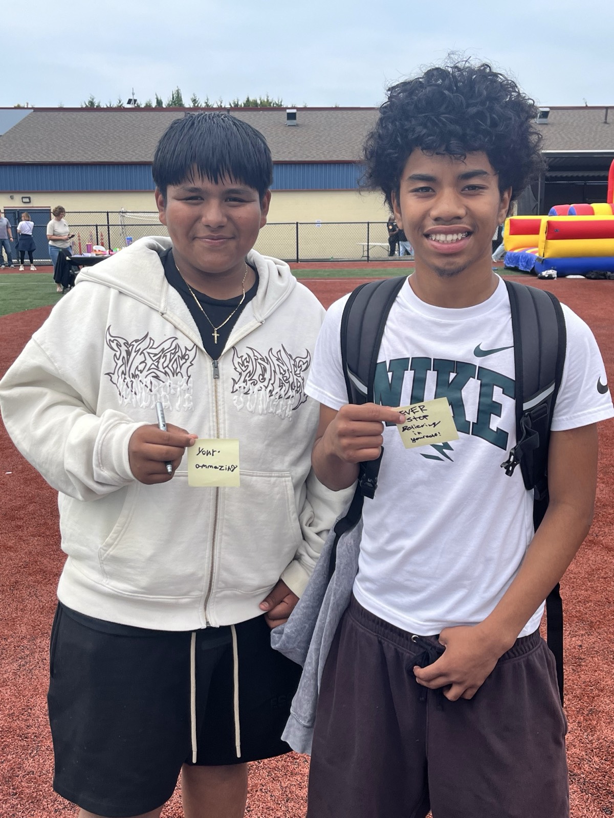 Two visitors with the notes they wrote for the board